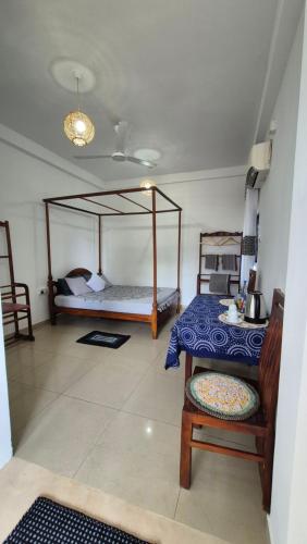 a bedroom with a bed and a table and a table and chair at NATIVE SOULS Beach Hotel in Induruwa