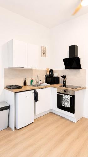 a kitchen with white cabinets and a stove top oven at Escapade Provencale in Lectoure