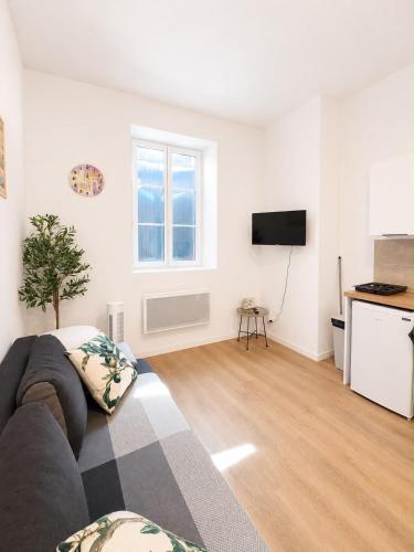 a living room with a couch and a kitchen at Escapade Provencale in Lectoure