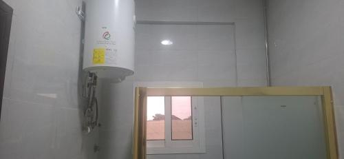 a white bathroom with a mirror and a window at TEE Guest House in Monrovia
