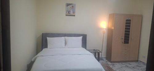 a small bedroom with a bed and a cabinet at TEE Guest House in Monrovia