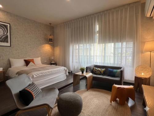 a bedroom with a bed and a living room at Ho.Me-Easyhouse in Tainan
