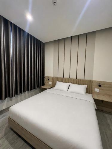 a large white bed in a room with windows at Saka Hotel in Plei Brel (2)