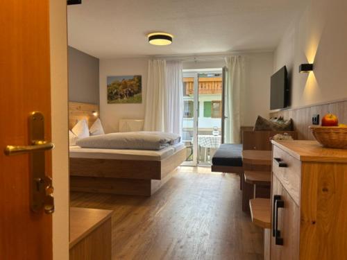a bedroom with a bed and a living room at Alpenrösle Ferienwohnungen - Berge - Ruhe - Traumaussicht 1-, 2- und 3-Raum-Wohnungen, Panoramasauna in Balderschwang
