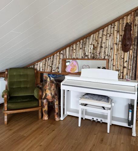 a room with a white piano and a green chair at Sunrise Loft in Bingen am Rhein
