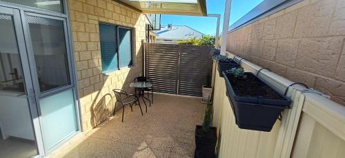 a balcony with a table and chairs on a building at Cosy Haven - Large Comfy Dwelling in Mandurah