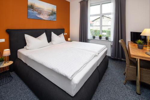 a bedroom with a large bed and a desk at Dahlbrucher Hof in Hilchenbach