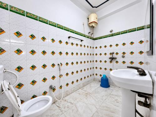 a bathroom with a toilet and a sink at The Binapani Hotel And Restaurant in Tarapith