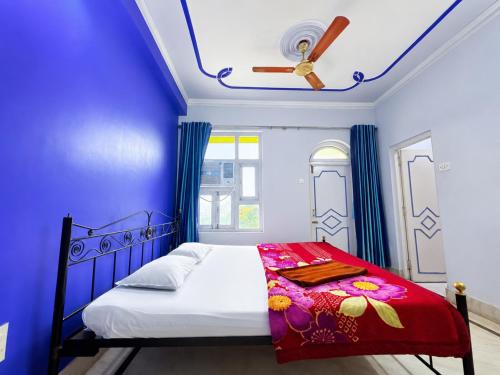 a bedroom with a bed with blue walls and a ceiling at The Binapani Hotel And Restaurant in Tarapith