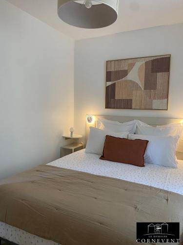 a bedroom with a large bed with white pillows at Appartement scandinave élégant, Domaine Cornevent Lyon, parc & piscine in Vernaison