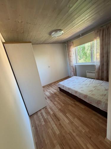 an empty bedroom with a bed and a window at 40m2 apartmnet in Viljandi