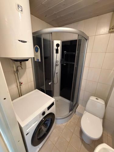 a bathroom with a washing machine and a toilet at 40m2 apartmnet in Viljandi