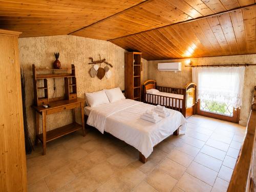 a bedroom with a bed and a table in a room at ALPE LUXURY ACCOMMODATION Penelope Collection in Olympiada