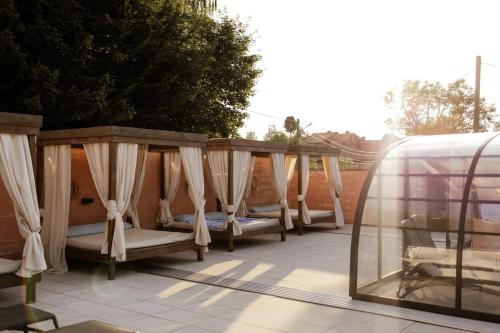 Eine Reihe von Betten mit Vorhängen auf einer Terrasse in der Unterkunft BOHO HOUSE in Ustrzyki Dolne