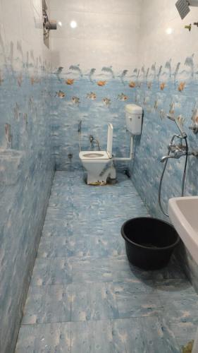 a bathroom with a sink and a toilet and fish mural at Mi HOMESTAY in Bikaner