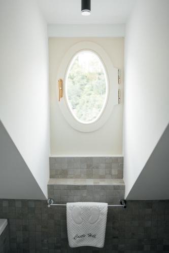 a bathroom with a window and a towel rack at Castle Hill Residence in Karlovy Vary