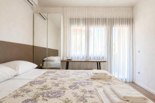 a bedroom with a large bed and a window at Apartments Mara near Split Airport in Kastel Stafilic