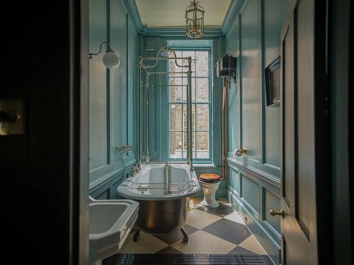 a bathroom with a tub and a sink and a window at Hazlitt's in London