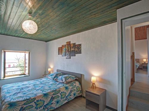 a bedroom with a bed and a wooden ceiling at Gîte Les Hortensias à Pralong - Charme et Confort pour 4 Pers avec Internet - FR-1-496-117 in Pralong