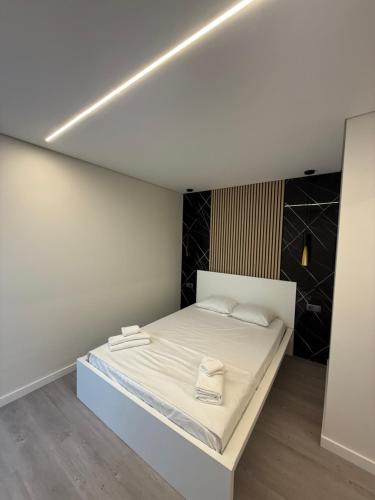 a bedroom with a white bed with a light on the ceiling at Casa Noir Luxury 3BR Apartment 2 Baths Near Lisbon & Sintra in Queluz