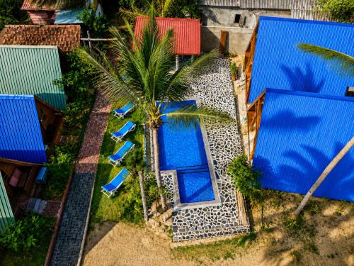 an overhead view of a pool with chairs and a palm tree at Sheen Coast Beach Cabana in Nilaveli