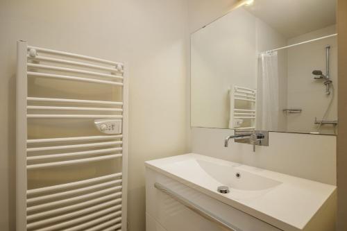 a white bathroom with a sink and a mirror at Wooden Villa 4 in Veyrier-du-Lac