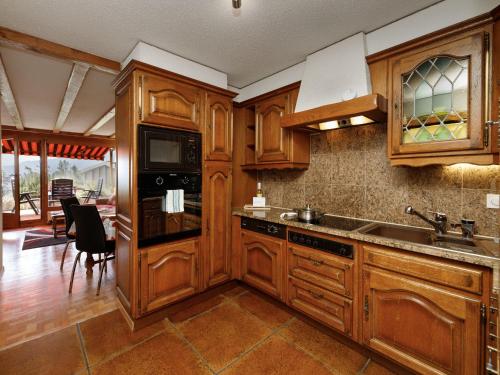 a kitchen with wooden cabinets and a sink at Apartment Terrasse Des Alpes 708 by Interhome in Vermala