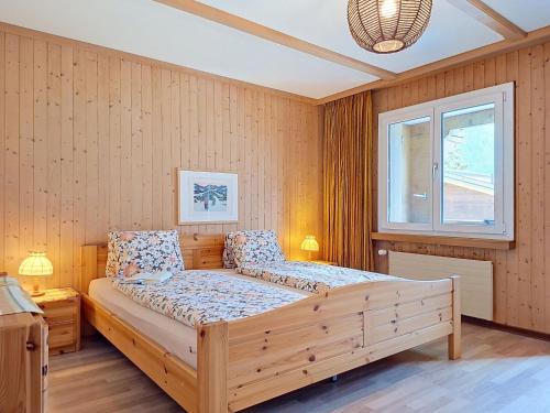 a bedroom with a wooden bed in a room at Apartment Chalet Almis 5 by Interhome in Grindelwald