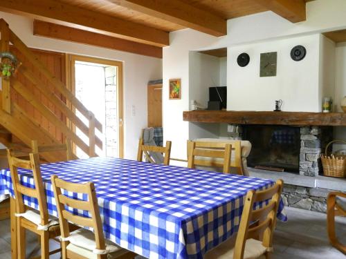 a dining room with a blue and white checkered table and chairs at Holiday Home Rustico Dara Cotta by Interhome in Alpe di Scieru