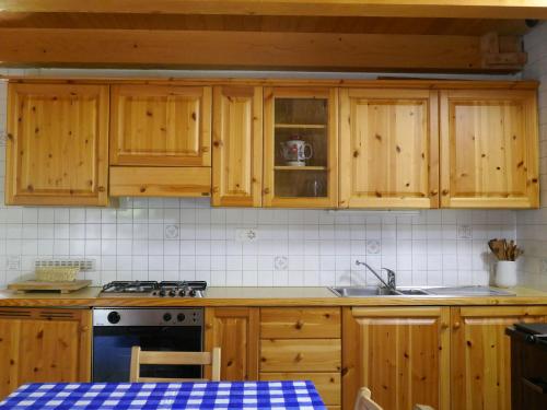 a kitchen with wooden cabinets and a stove at Holiday Home Rustico Dara Cotta by Interhome in Alpe di Scieru