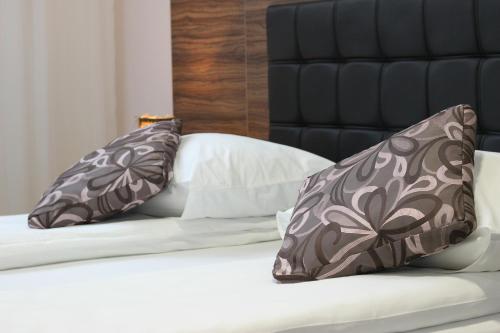 a bed with two pillows on top of it at Hotel Story in Sarajevo