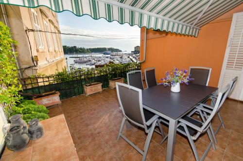 a table and chairs on a balcony with a view of a harbor at Apartment Noemi in Rovinj