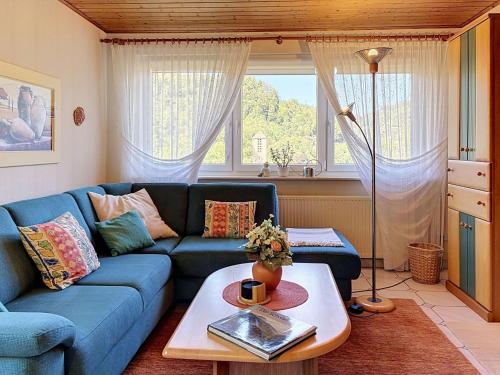 a living room with a blue couch and a table at Apartment Maier-1 by Interhome in Triberg
