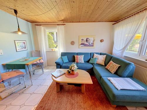 a living room with a blue couch and a table at Apartment Maier-1 by Interhome in Triberg