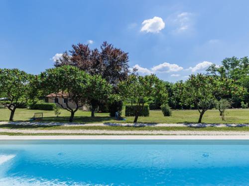 a swimming pool with trees and a house in the background at Holiday Home Tomazin by Interhome in Pazin