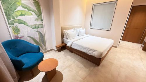 a bedroom with a bed and a blue chair at Oryana Resort in Udaipur