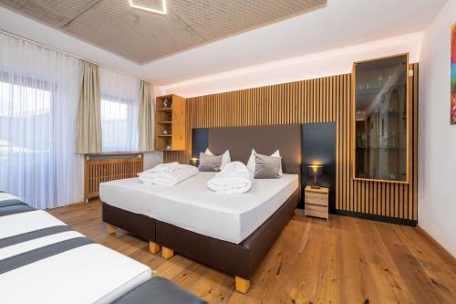 a bedroom with two beds with white pillows at Luxus Suite mit Whirlpool im Hotel Rupertihof in Ainring