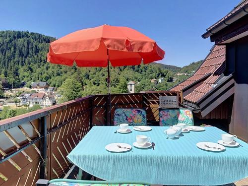 a table on a balcony with a red umbrella at Apartment Maier-2 by Interhome in Triberg