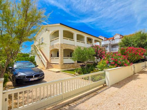 a house with a car parked in front of it at Apartman Adriatic View in Vir