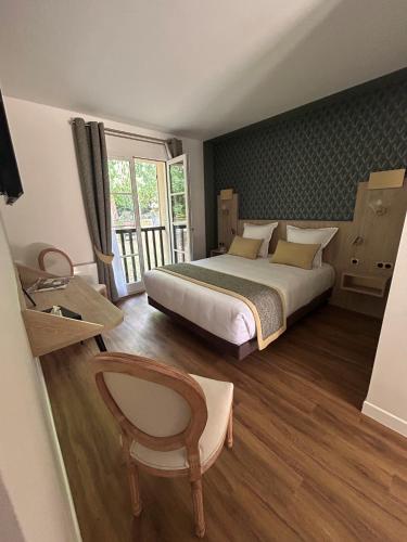 a bedroom with a bed and a large window at Hostellerie du Royallieu in Compiègne