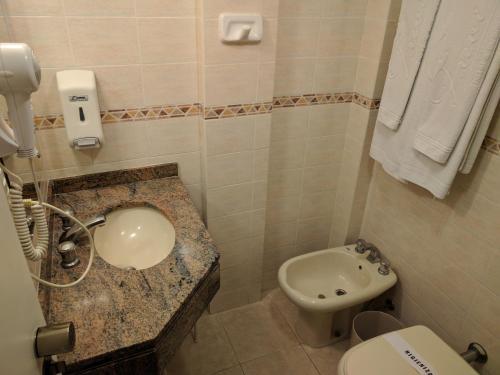 a bathroom with a sink and a toilet at Trevi Hotel e Business in Curitiba