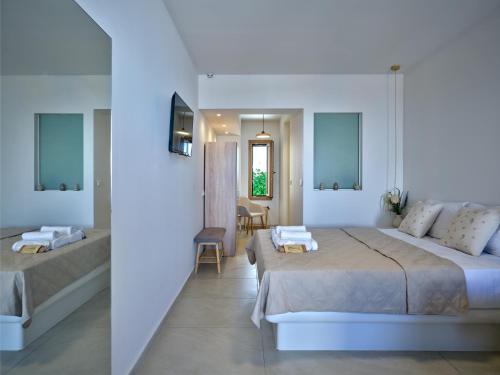a bedroom with a large bed and a living room at Rocaia Mini Suites Naousa in Naousa