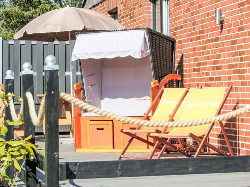 a chair and an umbrella next to a table and an umbrella at Holiday Home Weideblick by Interhome in Geestland