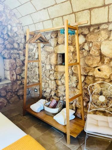 a room with a stone wall with a wooden shelf at Villa Eos - Villa con Piscina Privata nel cuore del Parco Naturale di Andrano in Andrano