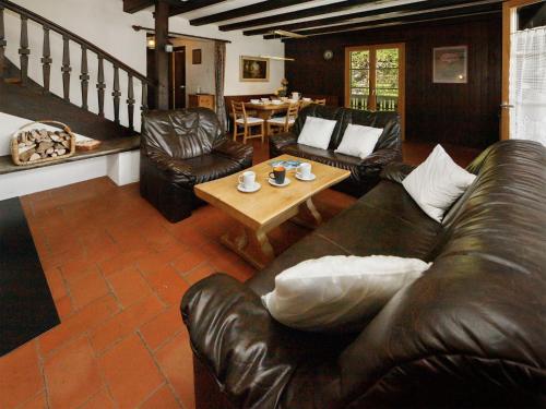 a living room with a leather couch and a table at Apartment Chalet L'Aube by Interhome in Vers L'Eglise