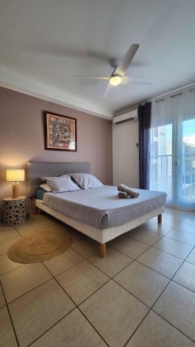a bedroom with a large bed with a ceiling fan at L'Arymarius 12 in Saint-Pierre