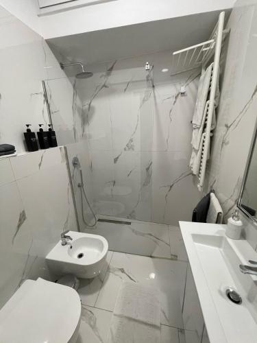 a white bathroom with a toilet and a sink at 16 zeros villa in Paralia Katerinis