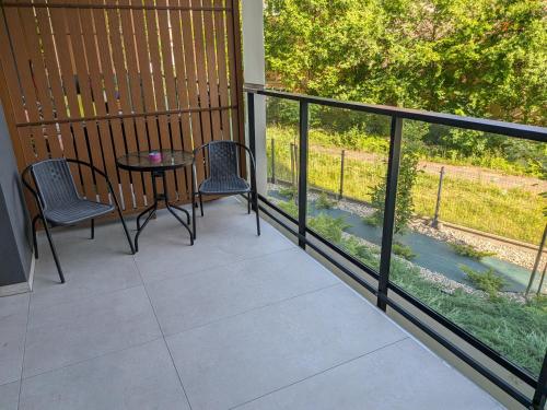 a balcony with two chairs and a table on it at Apartament Klonova na Mazurach in Olecko