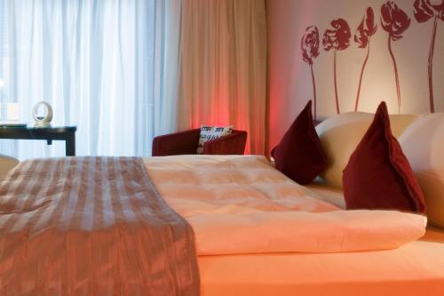 a hotel room with a bed and a chair at Atrium Hotel Mainz in Mainz