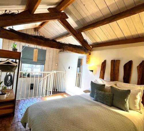 a bedroom with a large bed in a room with wooden ceilings at Ostalon de Sénégats in Lacaze